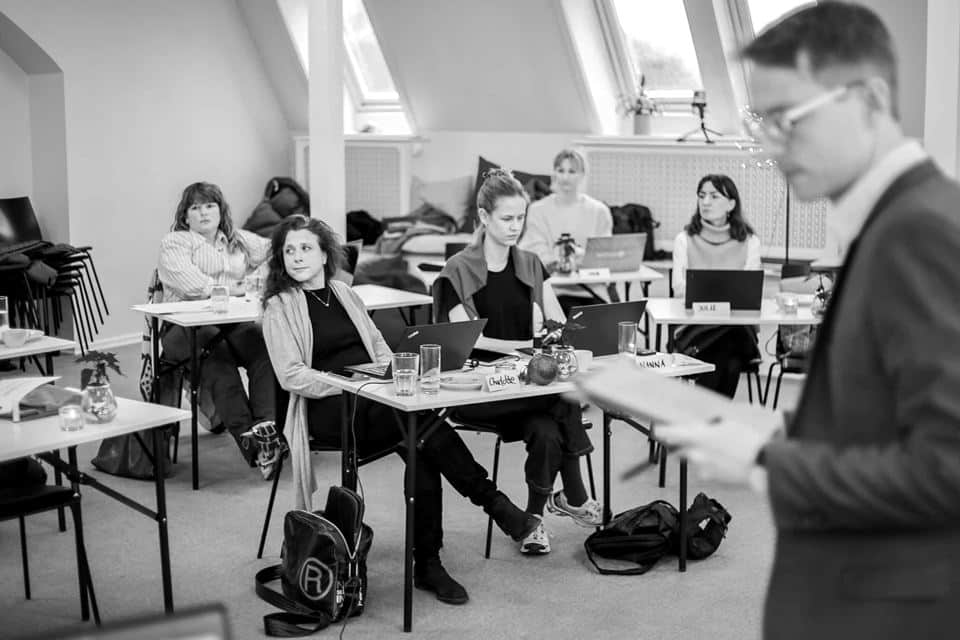 Kursister med bærbare computere lytter med under undervisningen