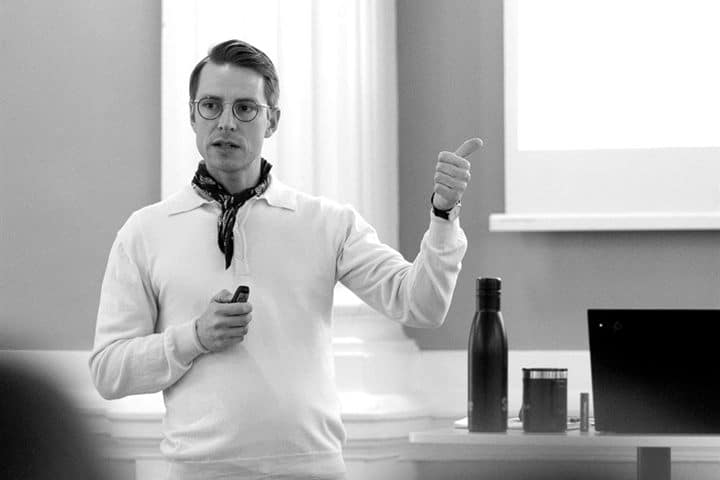 Simon Linde holder oplæg med fjernbetjeningen i hånden og peger på lærredet bag sig